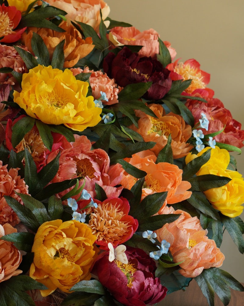 A parasol do handcrafted crepe paper peonies in yellows and pinks