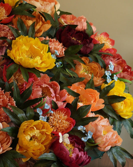 A parasol do handcrafted crepe paper peonies in yellows and pinks