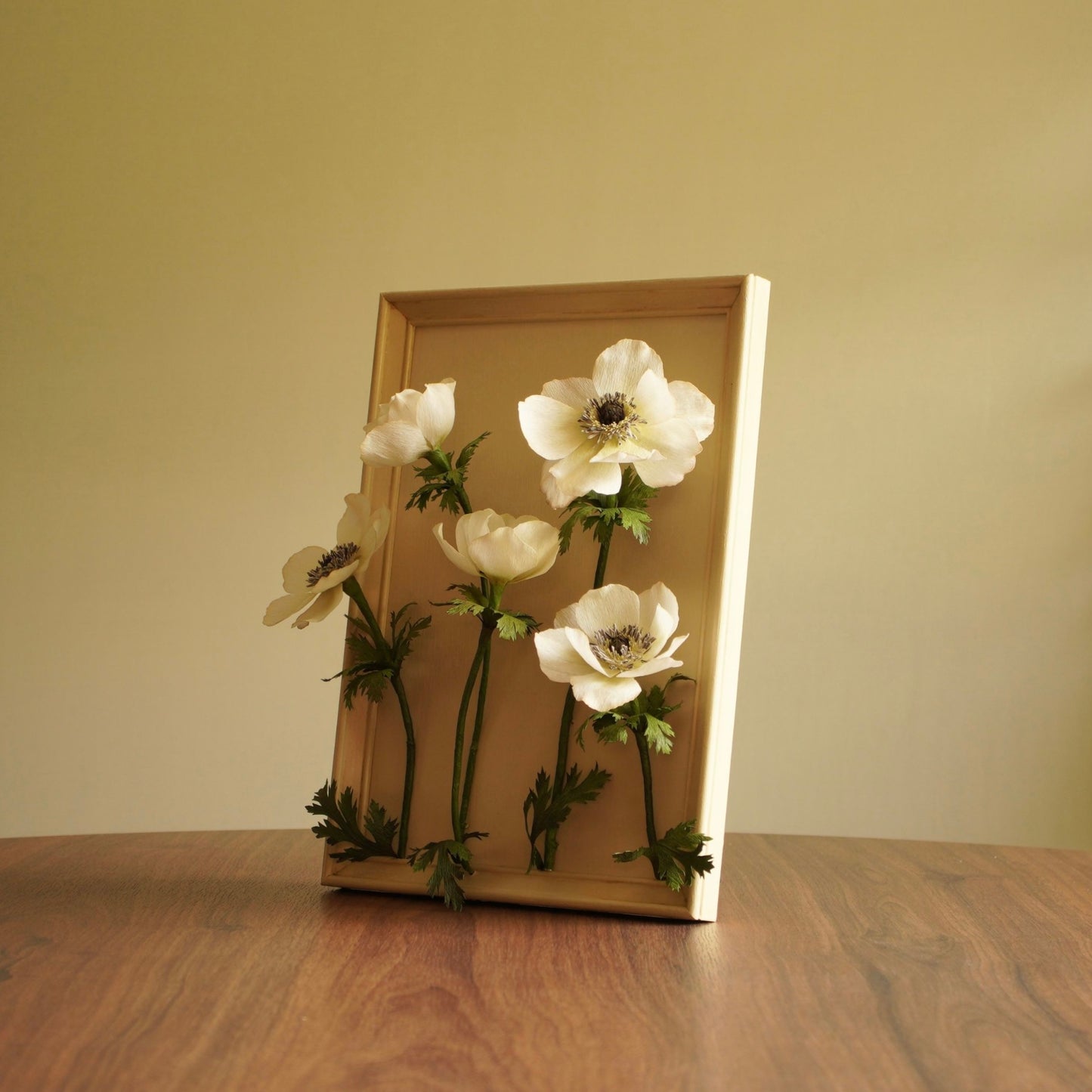 Angled view of a framed paper anemone artwork showing the sculptural depth f the flowers and stems