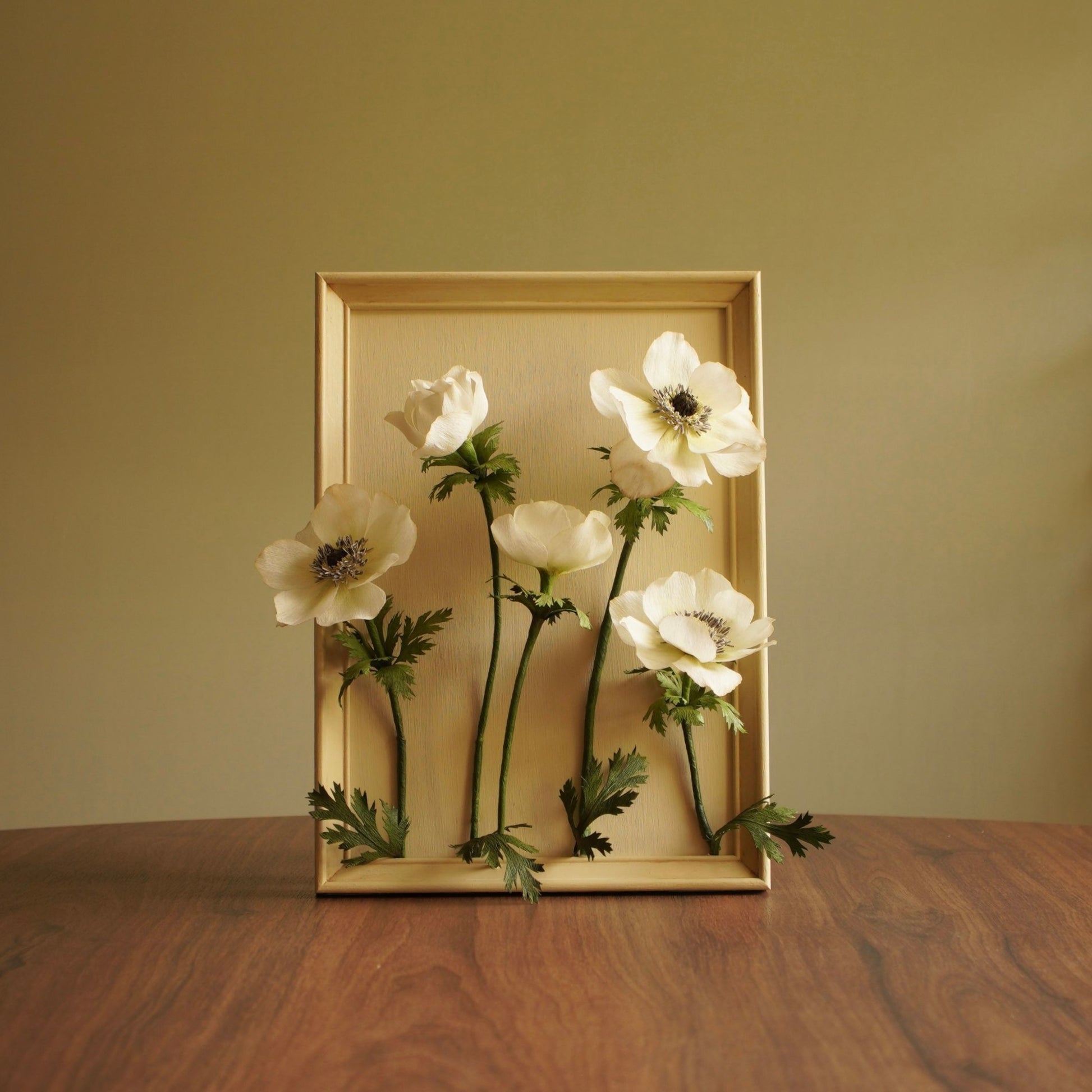 Full composition of a framed paper botanical artwork featuring five white anemone flowers
