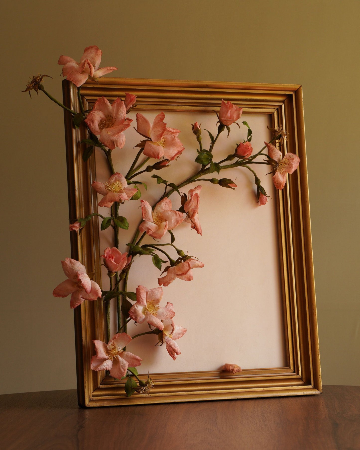 Framed artwork with pink floral design on a beige background