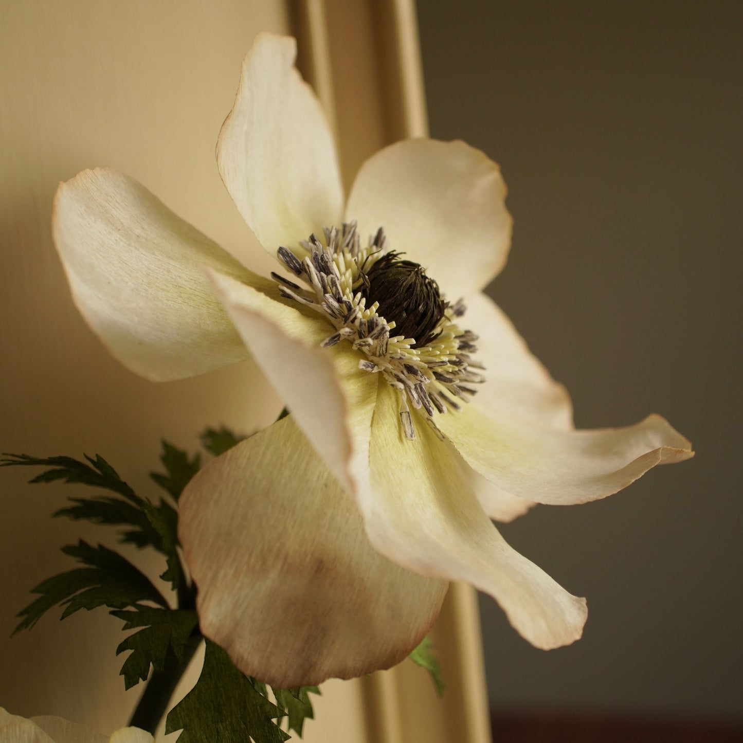 Close up of a handcrafted paper anemone flower showing detailed petals and centre