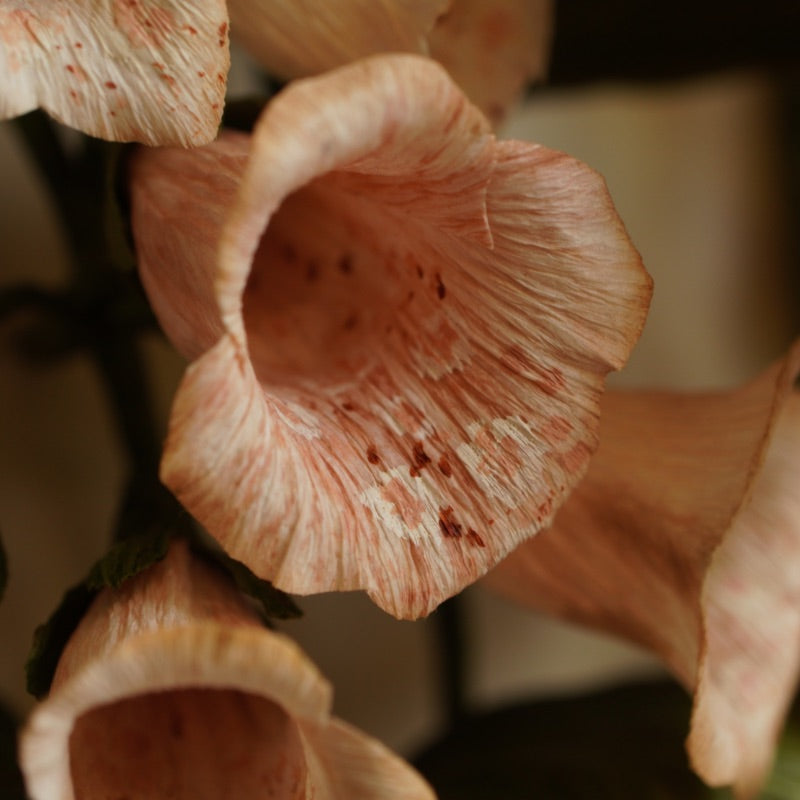 Close up detail of handcrafted paper foxglove flowers with softly painted petals and speckled interiors
