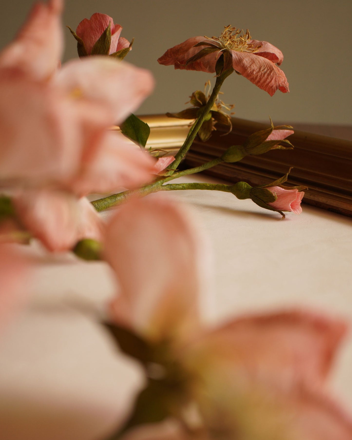 Close up of a fading pink paper rose with missing petal
