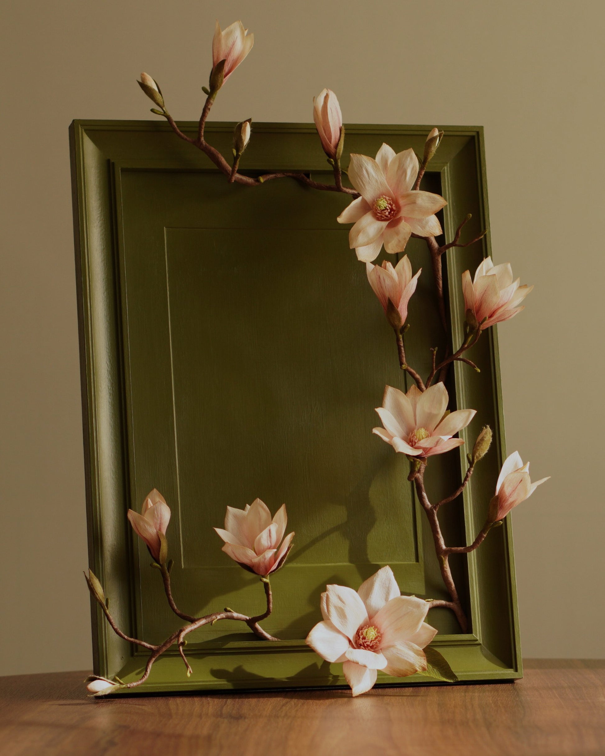 Full view of framed magnolia artwork showing placement of blooms and branch across frame